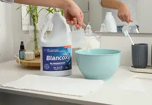 persona vertiendo producto Blancox en una vasija 